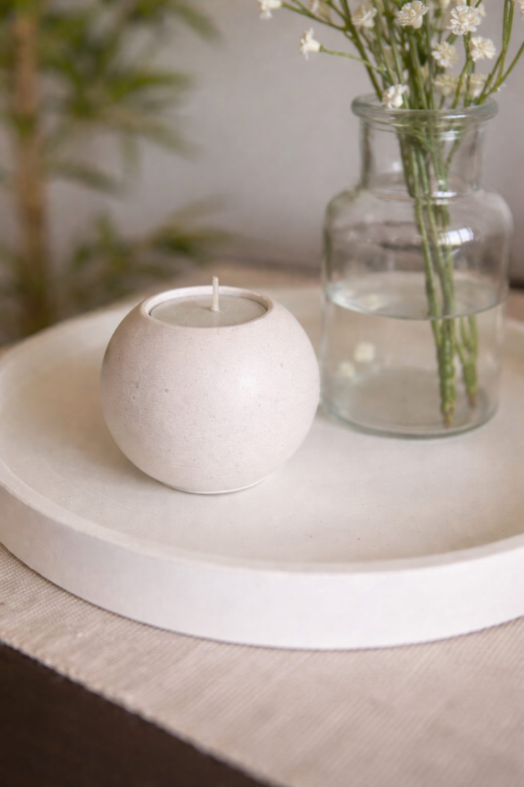 Spherical candle on a round stone tray